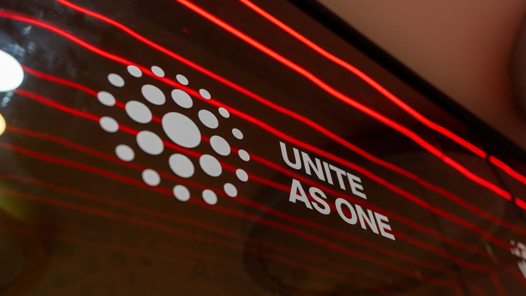 Close-up of a value icon and slogan printed on a glossy red and black glass panel