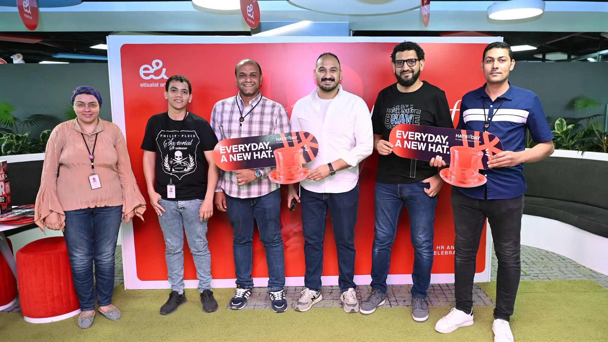 Six HR colleagues, women and men, stand together smiling at a celebration booth