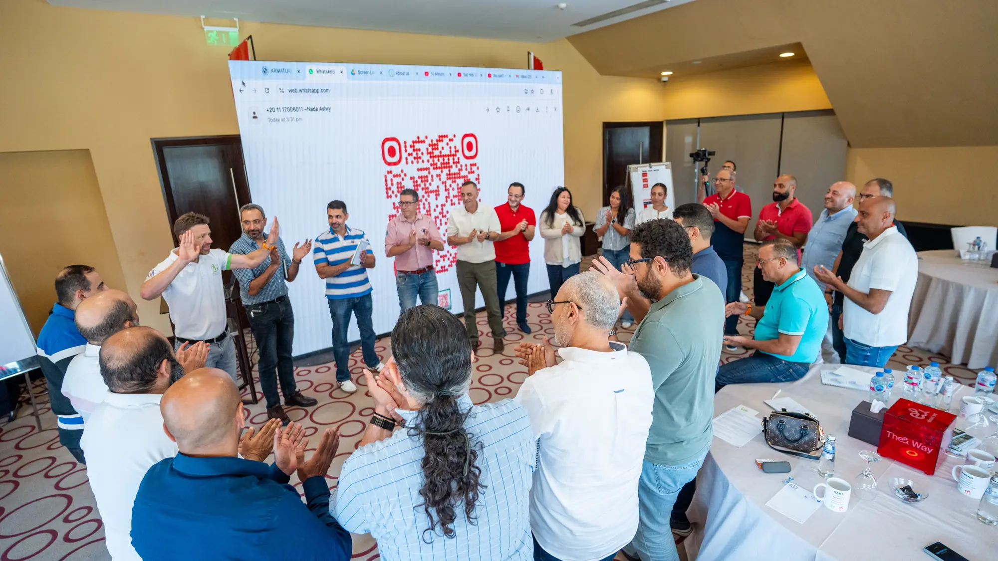 Managers stand in a circle clapping during an energising group exercise at a workshop