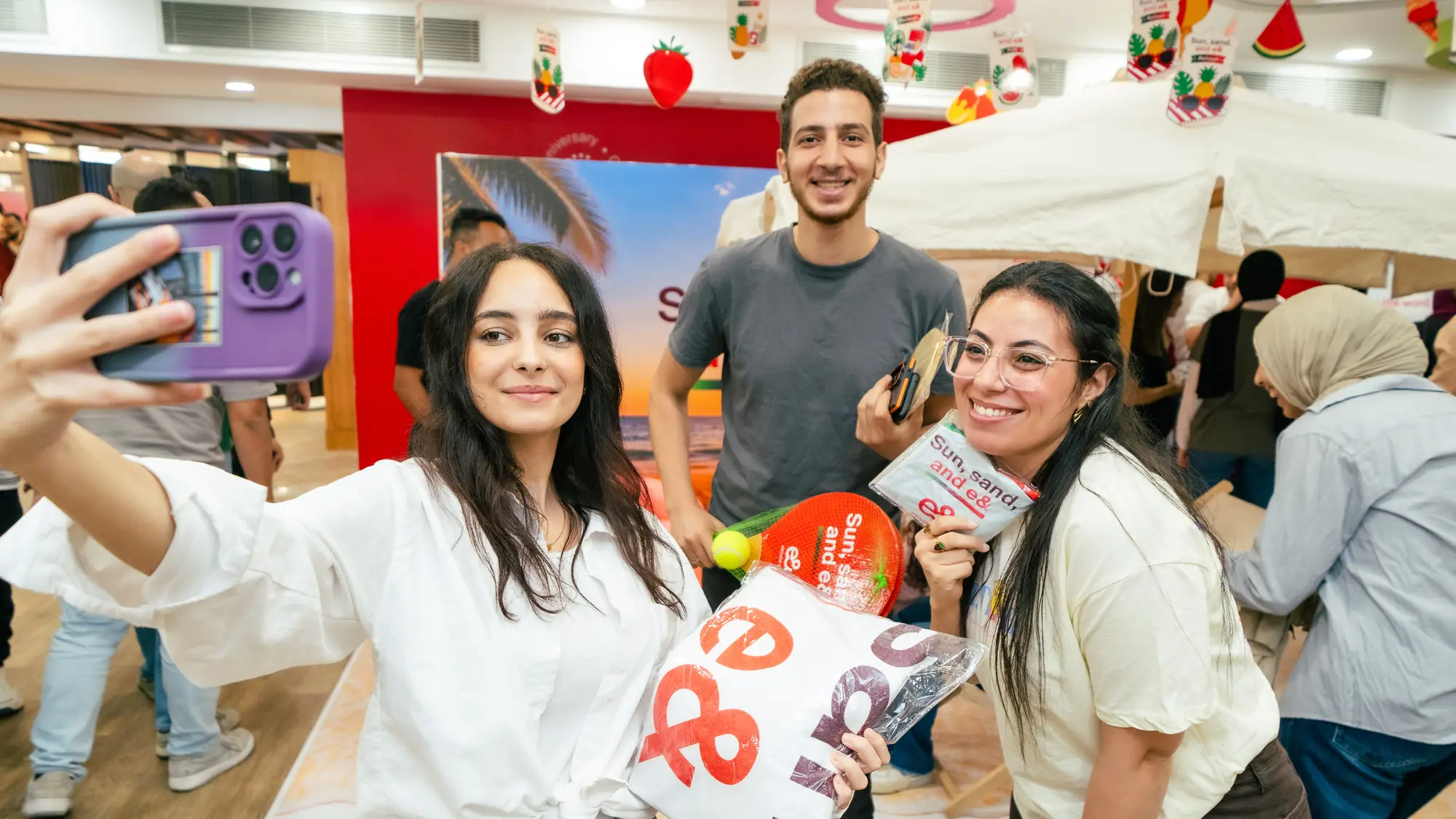 Colleagues take a playful selfie with summer props and beach giveaways
