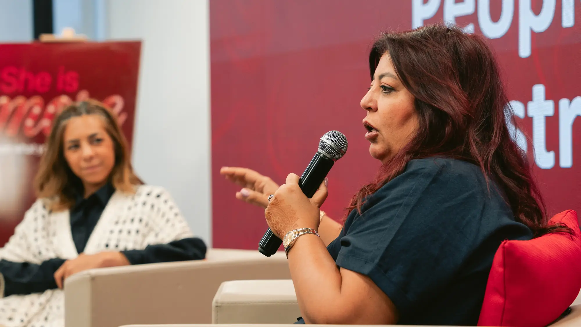 متحدثة خبيرة توضح وجهة نظرها باستخدام الميكروفون خلال جلسة نقاشية.